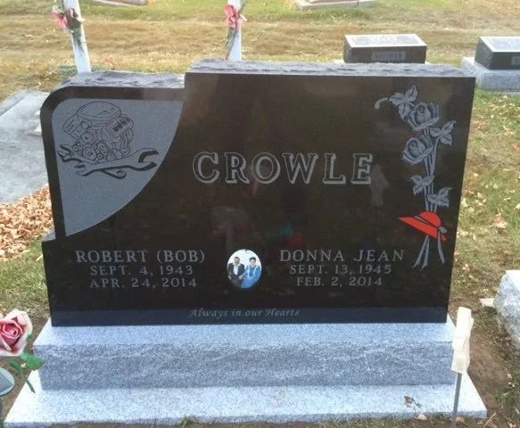 Black Crowle gravestone with engraved names and floral designs in a cemetery