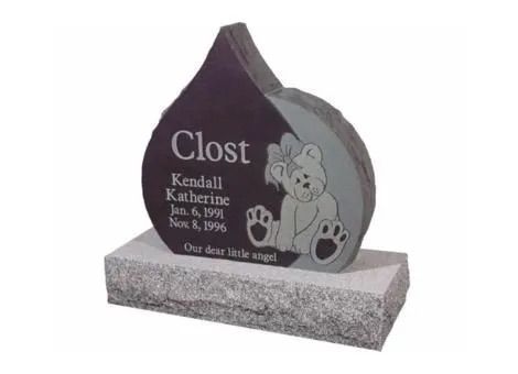 Black granite memorial headstone with engraved name, dates, and a cartoon dog on a gray base