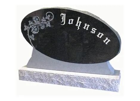 Black oval memorial plaque with floral design and the name “Johnson” on a gray base