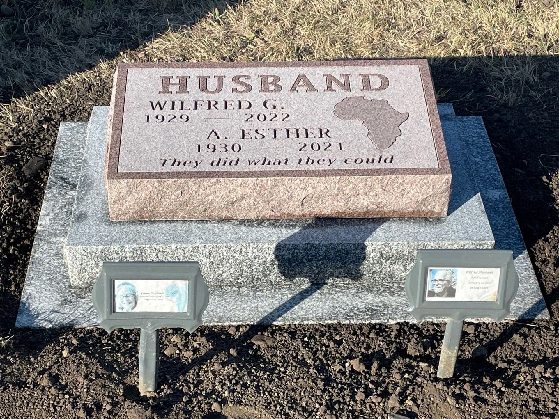 Granite headstone with engraved plaque listing two names, birth and death dates, and epitaph