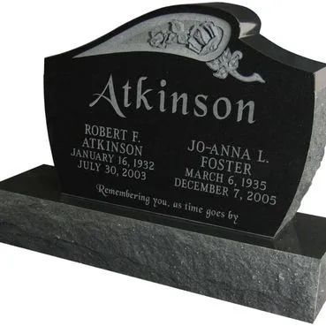 Black granite Atkinson memorial headstone with carved floral top and engraved names and dates.