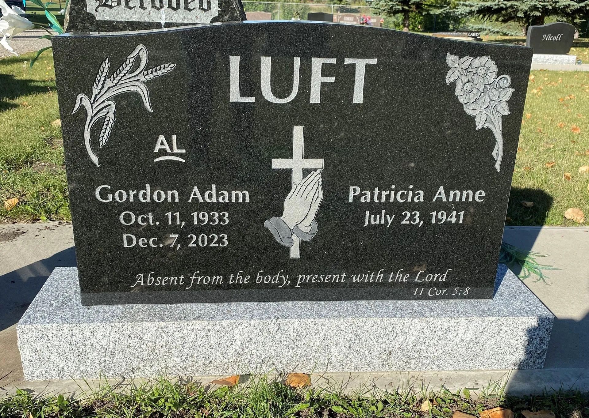 Black granite memorial gravestone for Gordon Adam and Patricia Anne LUFT with floral engravings.