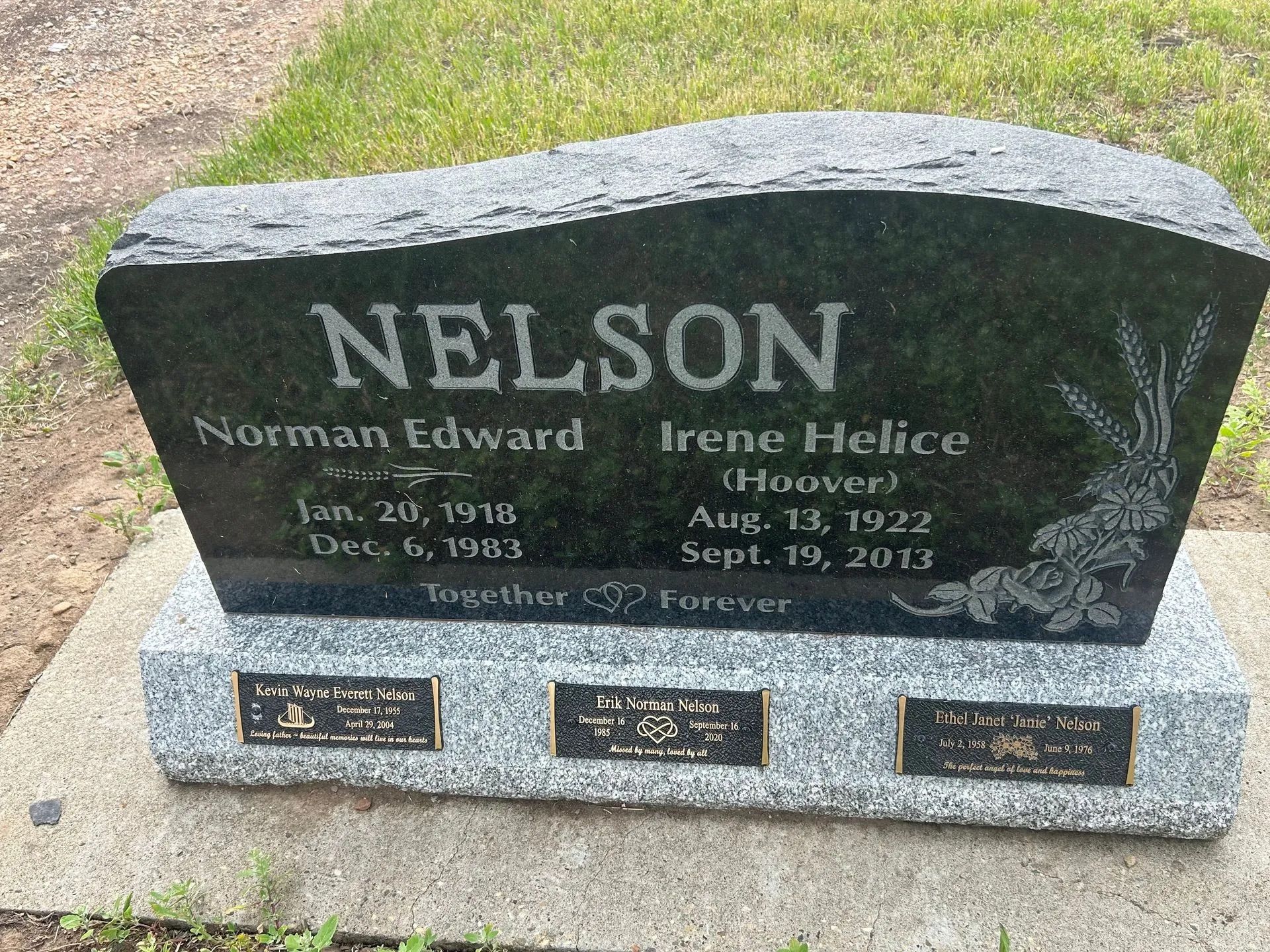 Nelson family gravestone with engraved names on a dark granite headstone in a cemetery