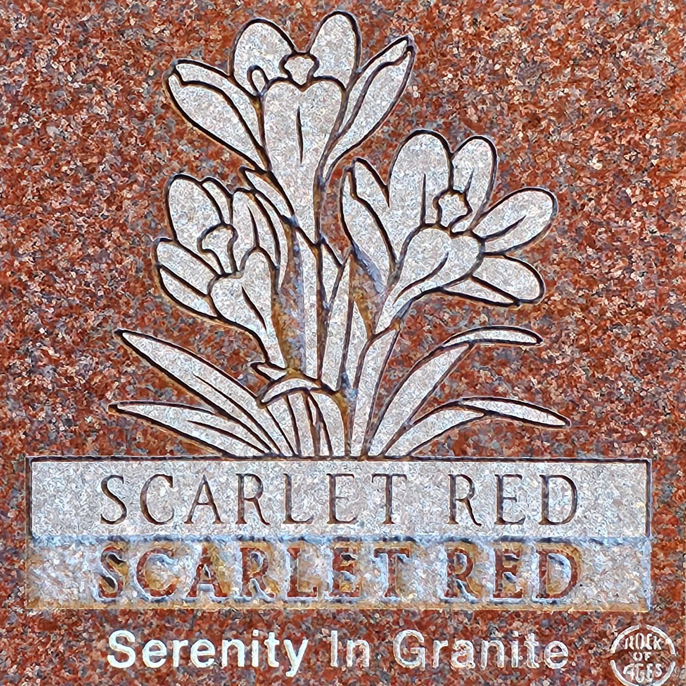 Floral memorial plaque reading “Scarlet Red” and “Serenity In Granite” on a speckled granite background