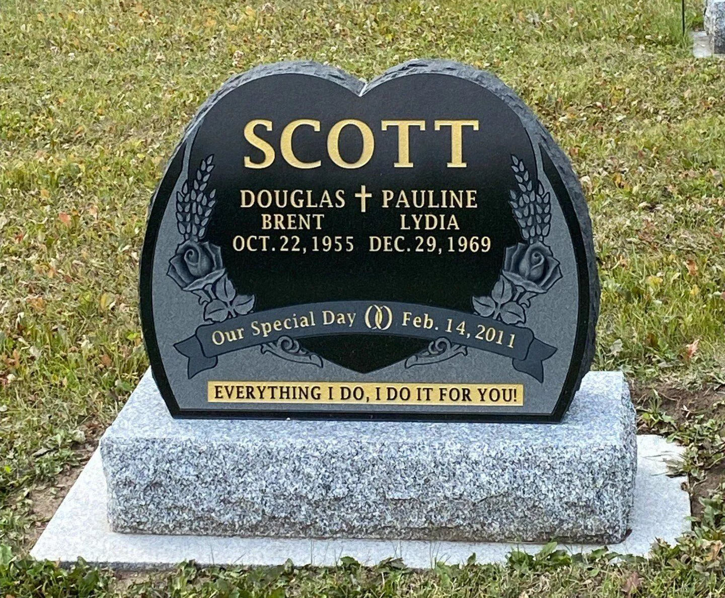Black memorial gravestone for Scott and daughters Brent and Lydia in a grassy cemetery, with gold lettering.