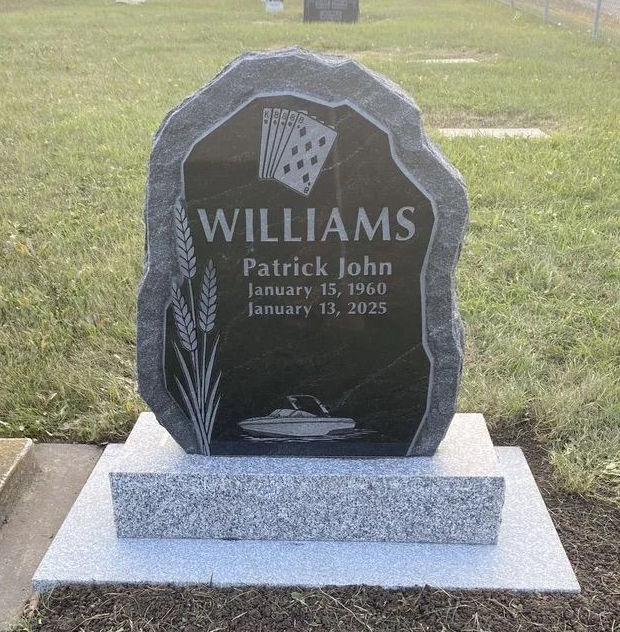 Black upright gravestone with name “Williams” and engraved dates, set on a grassy lawn.