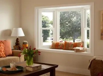 A beautiful bay window with pillows and vinyl frames
