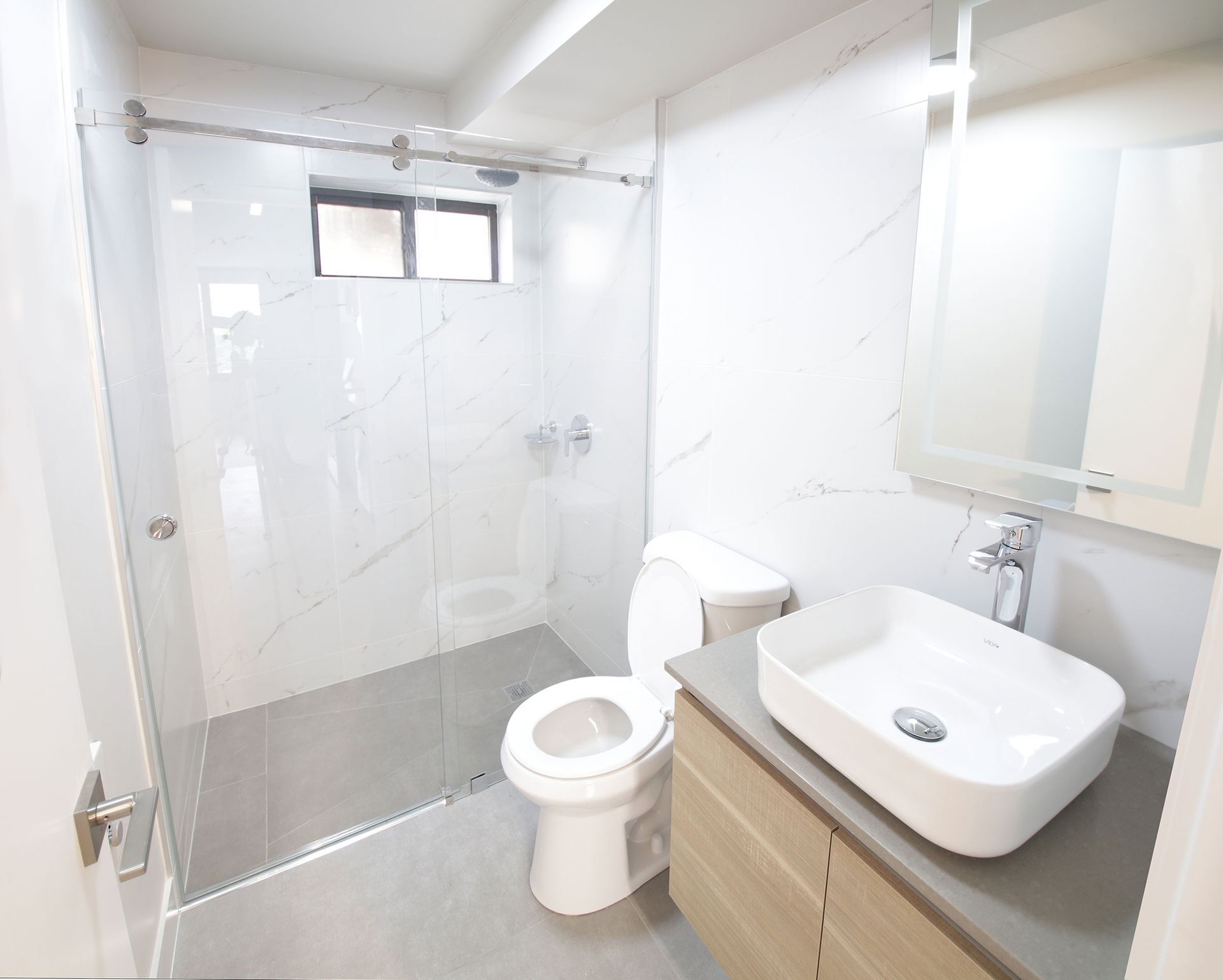A bathroom with a toilet a sink and a shower