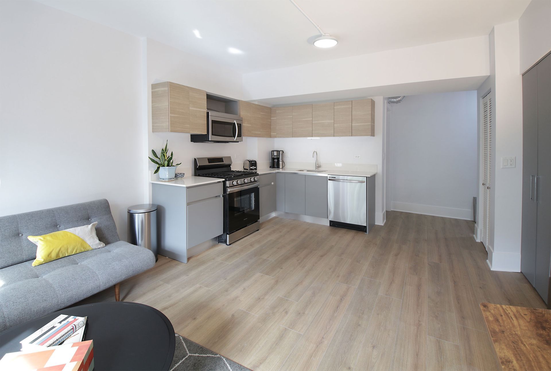 A living room with a couch and a kitchen