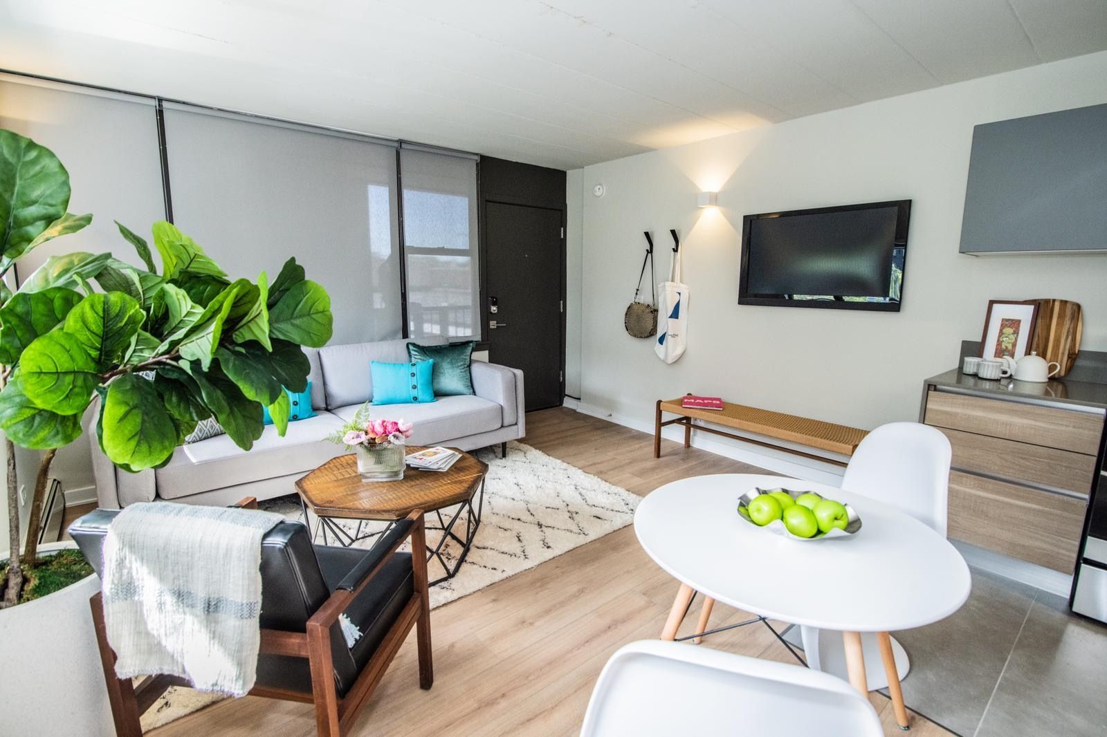 A living room with a couch , chair , table and television.