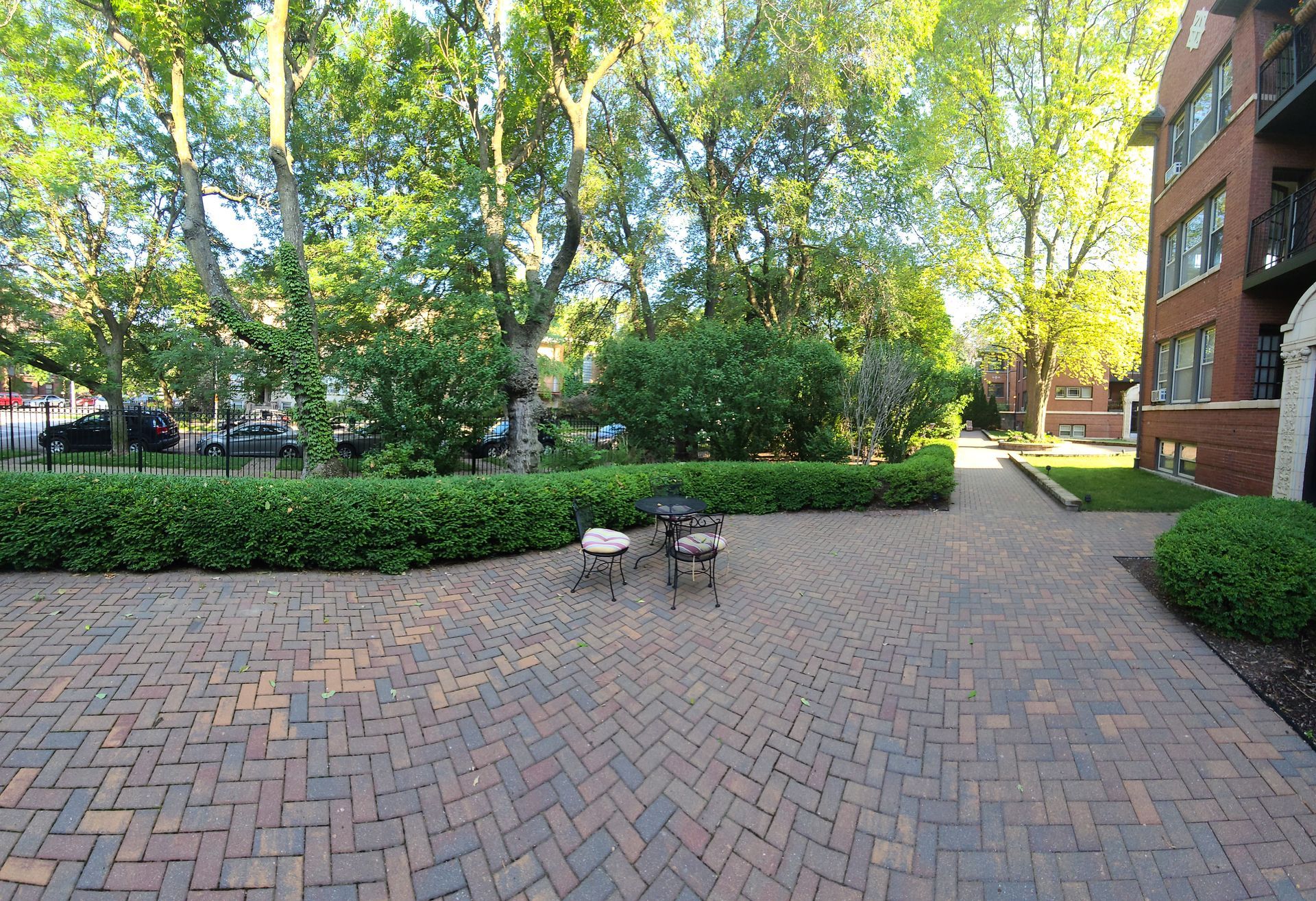 A brick patio with a table and chairs in front of a building