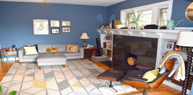 A living room with a fireplace , couch , chair and rug.