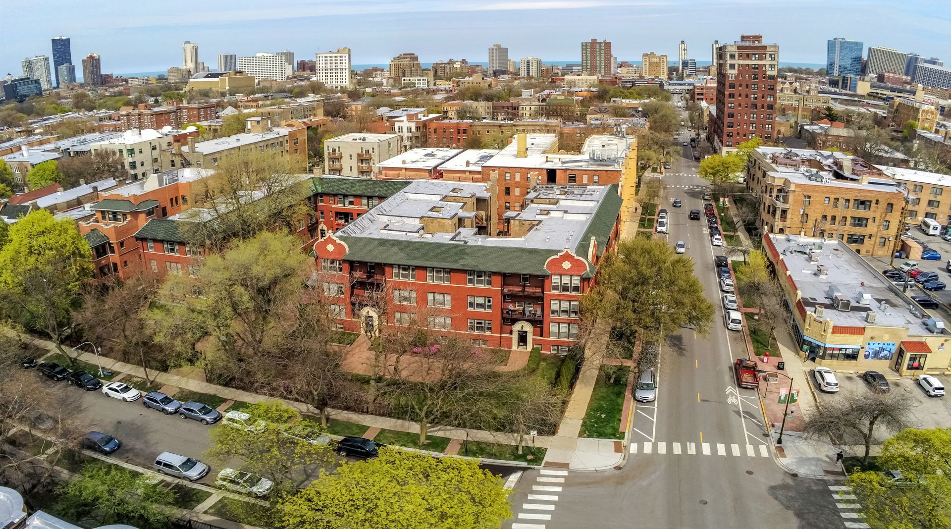 An aerial view of a city with a large red building in the middle