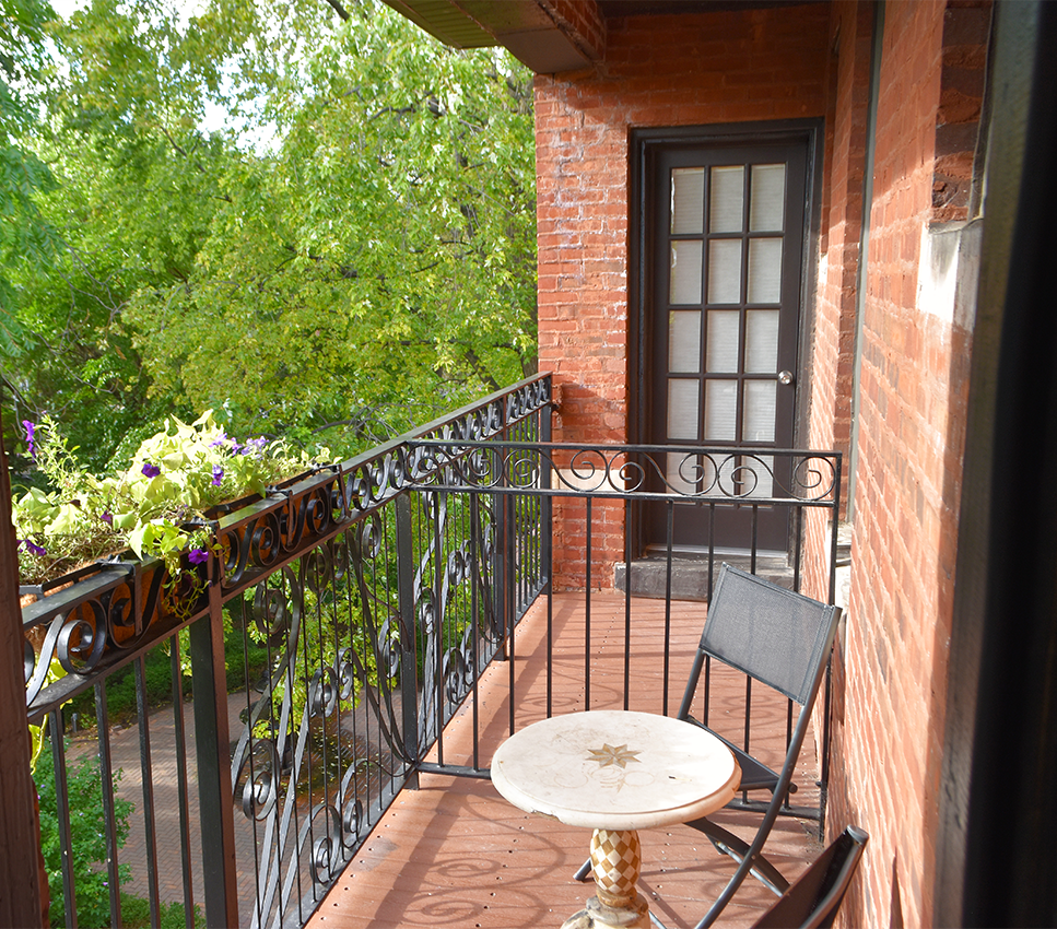 A balcony with a table and chairs on it