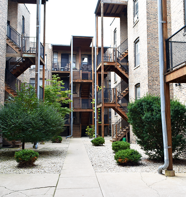 A brick building with stairs leading up to the second floor