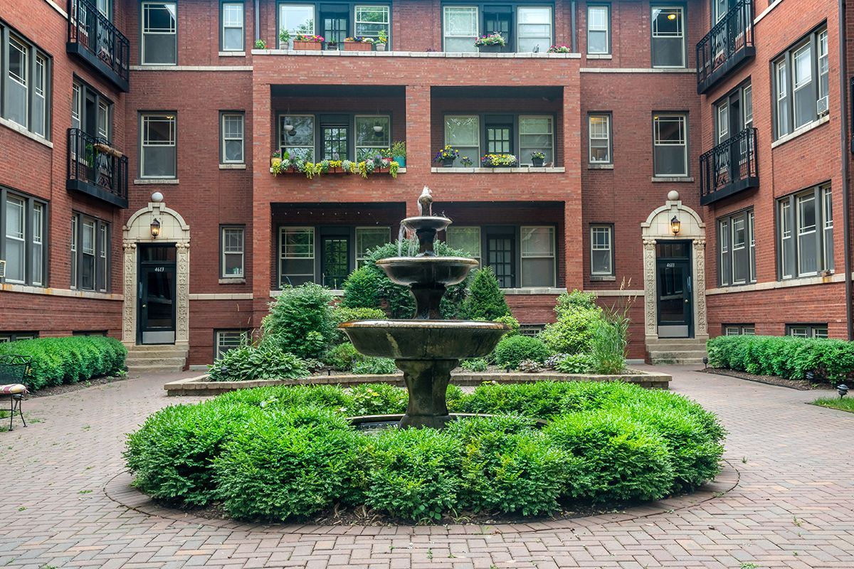A brick building with a fountain in the middle of it