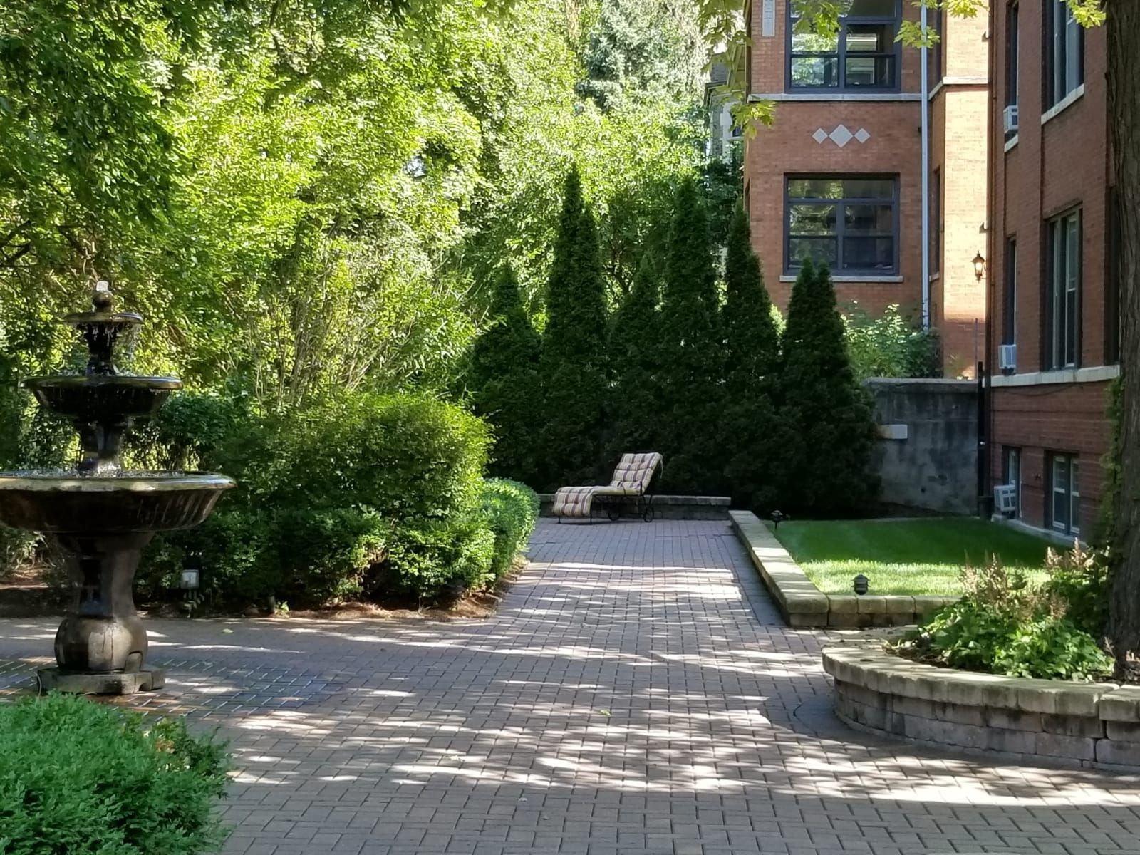 A brick walkway with a fountain in the middle of it