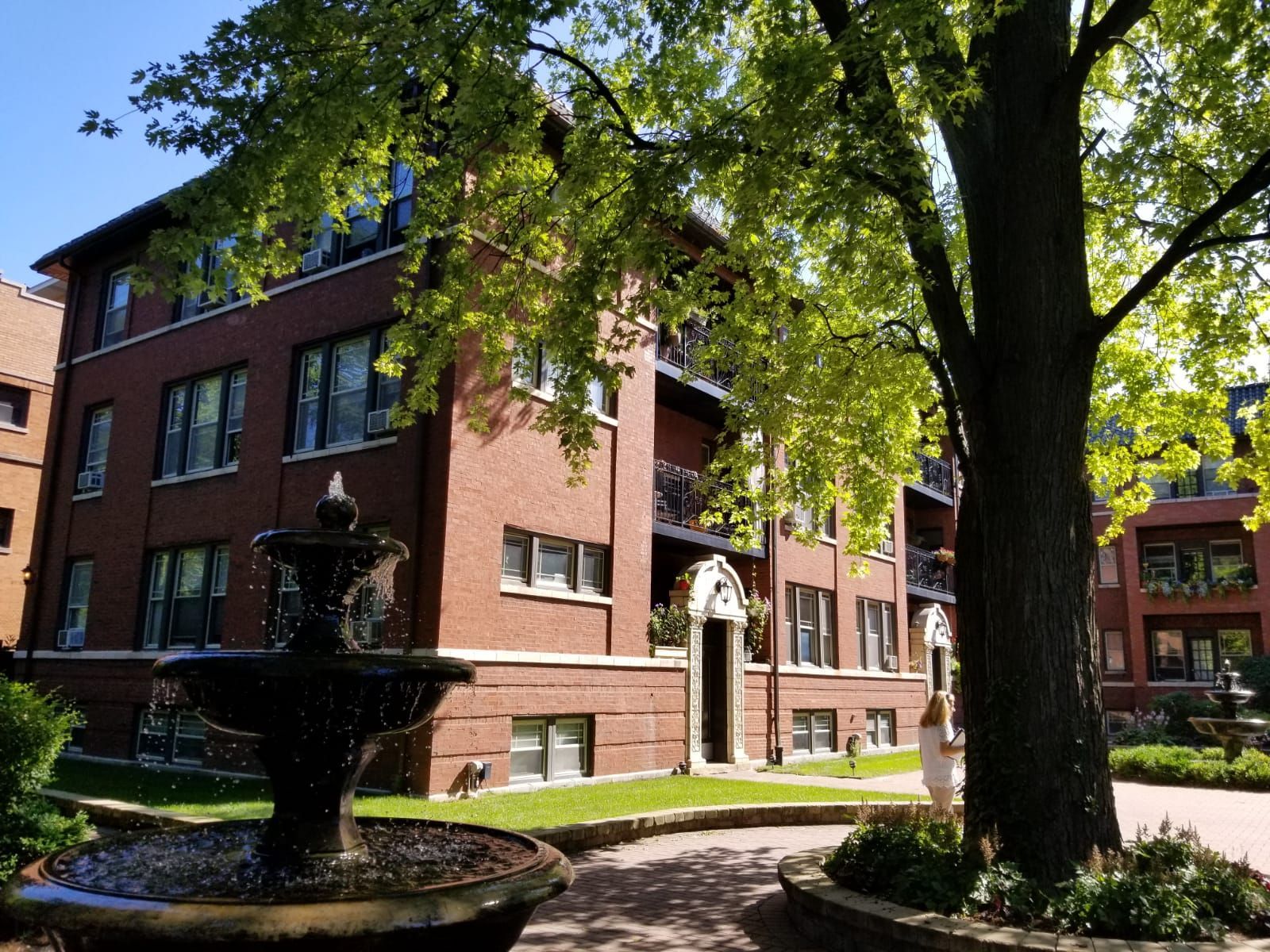 A brick building with a fountain in front of it