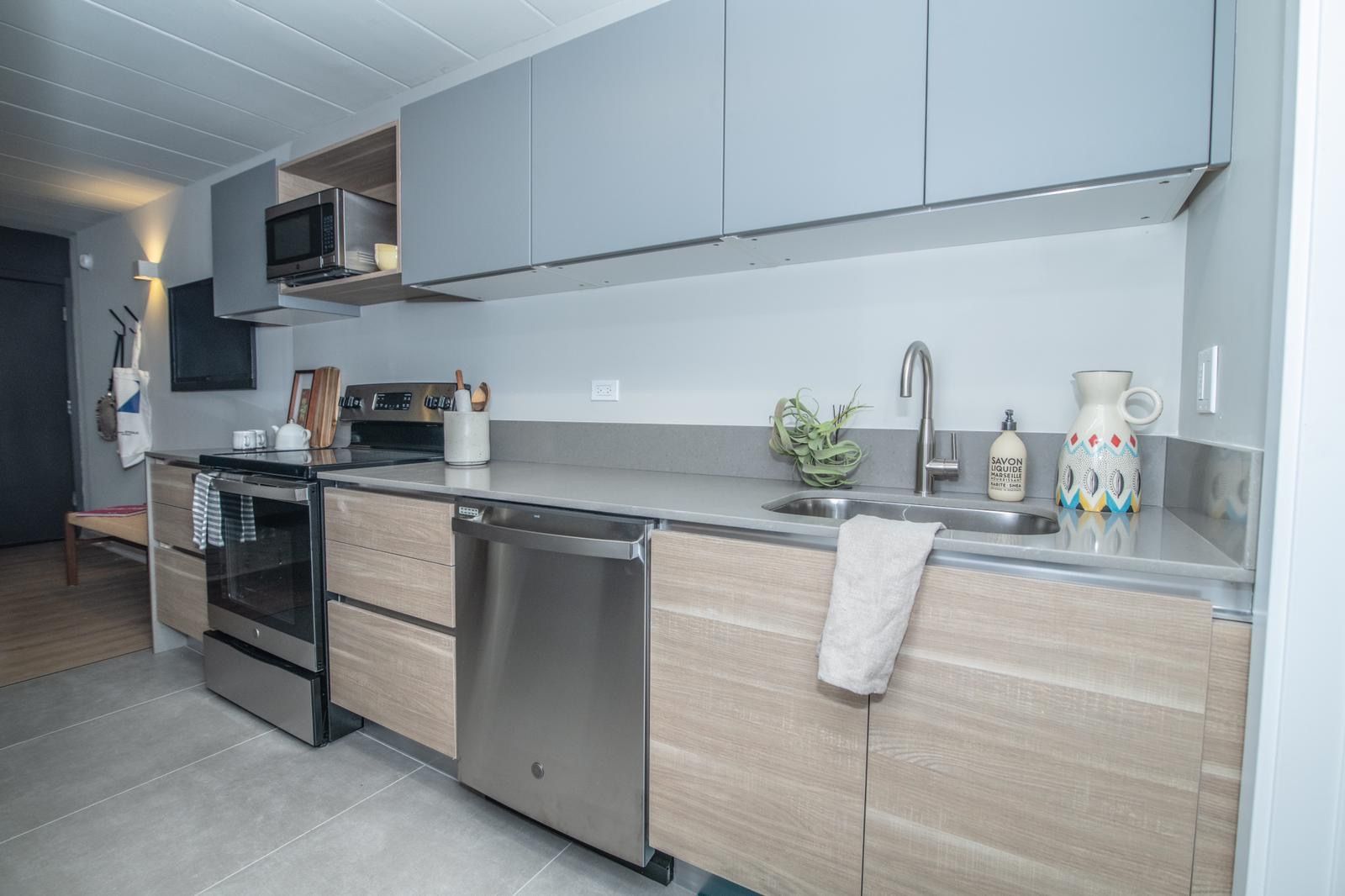 A kitchen with stainless steel appliances and wooden cabinets.