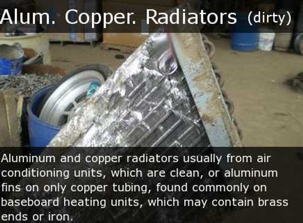 Dirty aluminum and copper radiators piled in a scrapyard.