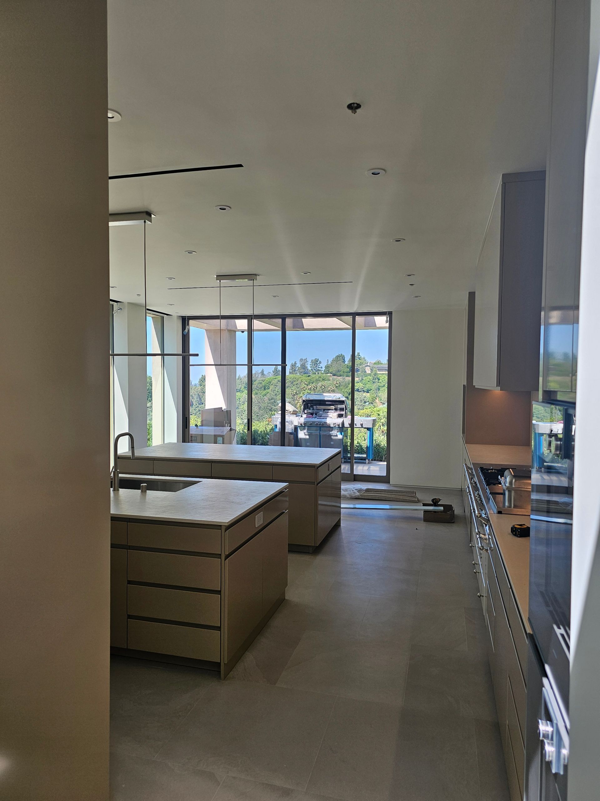 Empty modern kitchen under renovation with island cabinets and large windows overlooking mountains