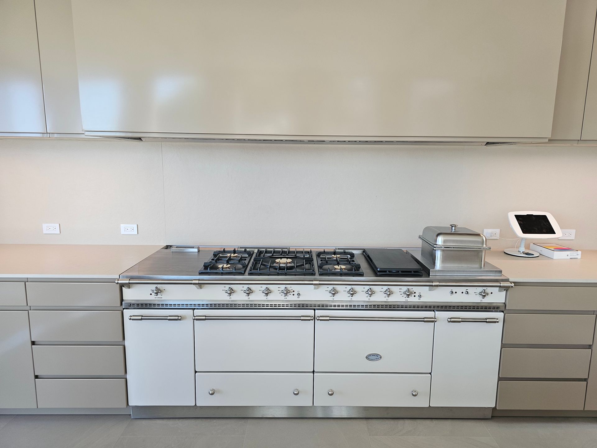 Modern kitchen with a large stainless steel gas range and built-in cabinets, viewed straight on