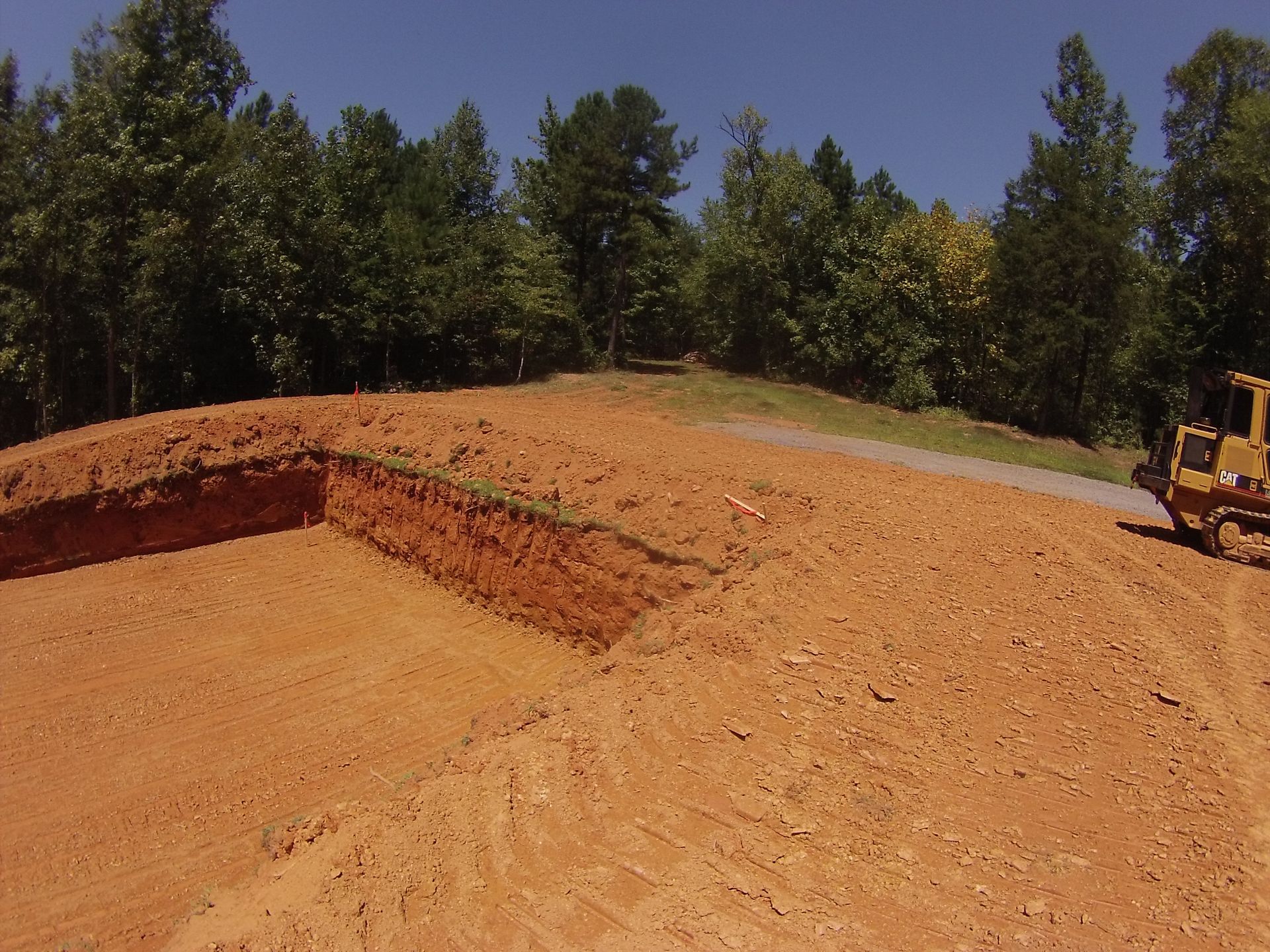 A yellow bulldozer is digging a hole in the dirt