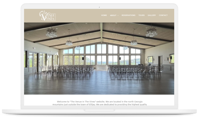 A laptop screen shows a large room filled with chairs and tables.