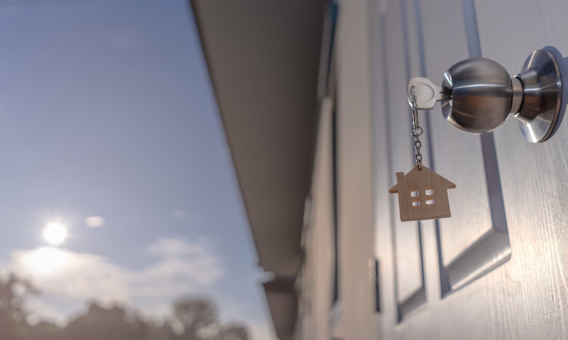 A Door with A Key and A House Keychain on It — Cairns Property Collective in Trinity Park, QLD