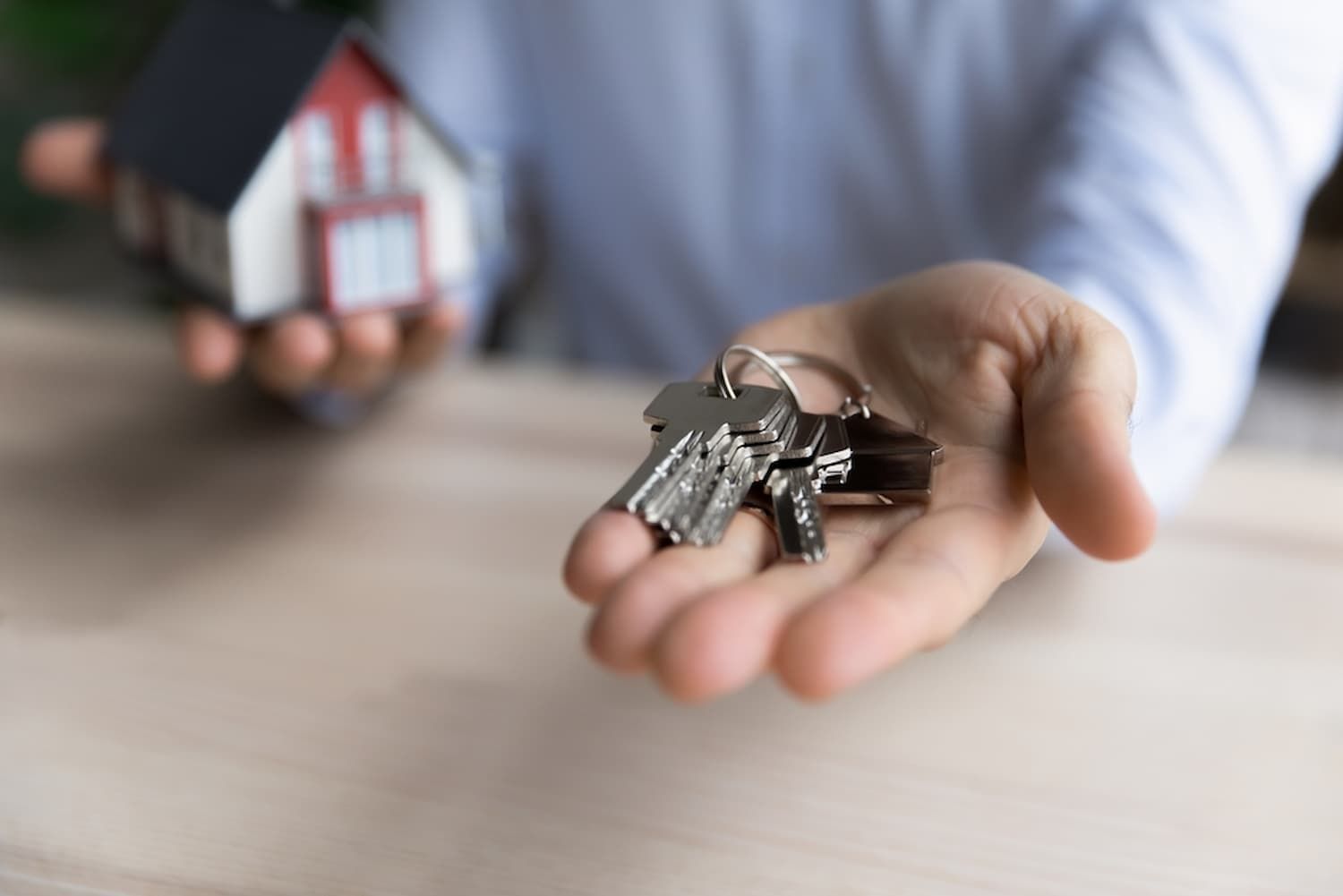 A Person Is Holding a Bunch of Keys and A Small House in Their Hand — Cairns Property Collective in Trinity Park, QLD