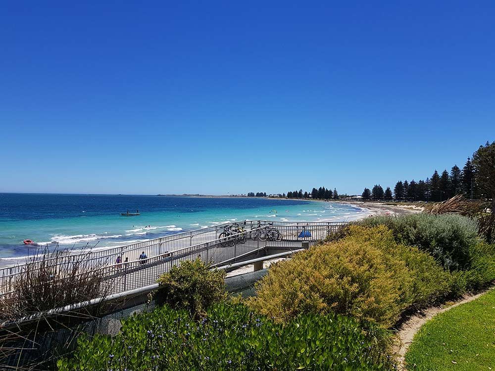 A View of a Beach With a Boardwalk Leading to the Ocean — Cairns Property Collective in Bentley Park, QLD