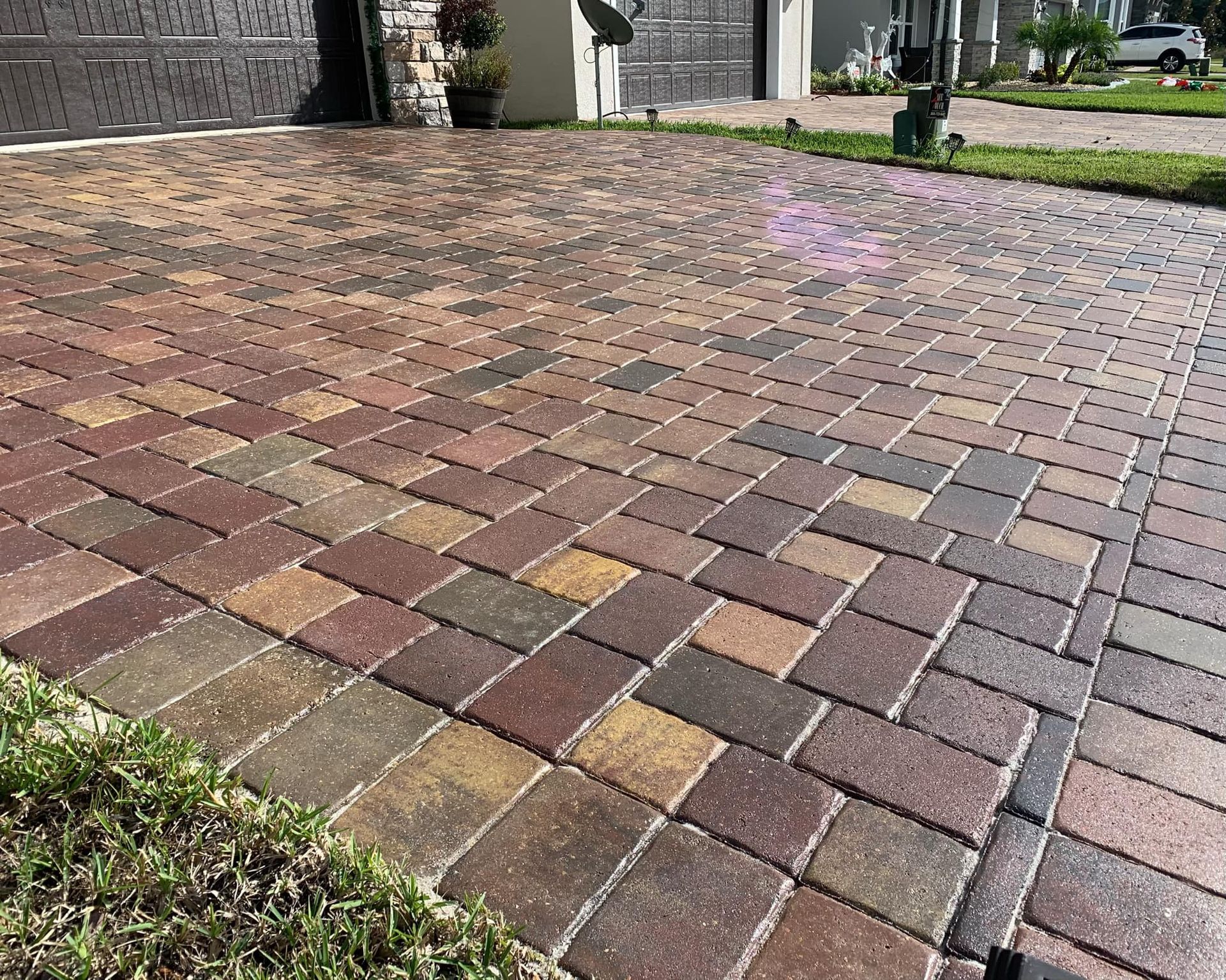 A close up of a brick driveway in front of a house.