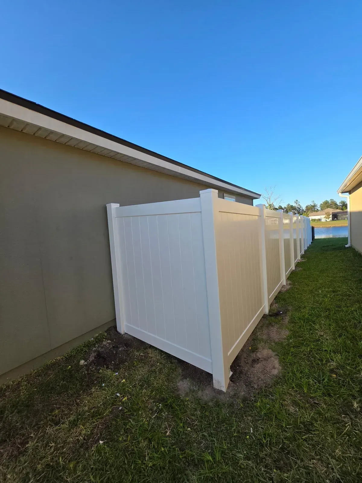 White vinyl fence and gate closing a narrow residential side yard