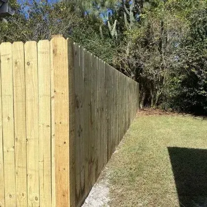 Dog-ear wood privacy fence bordering a wooded rear lot