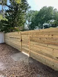 Horizontal wood fence built with horizontal boards and an integrated gate