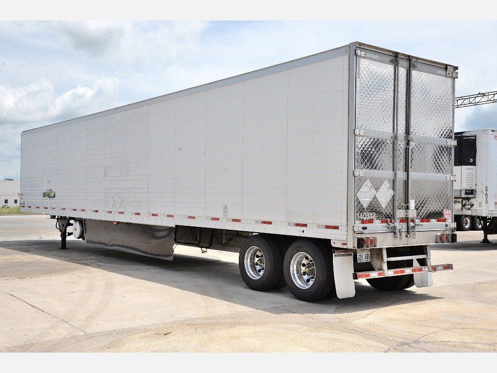 A white semi truck is parked in a parking lot.