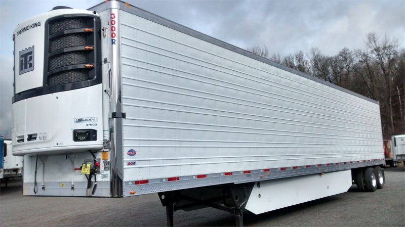 A white semi truck is parked in a parking lot.