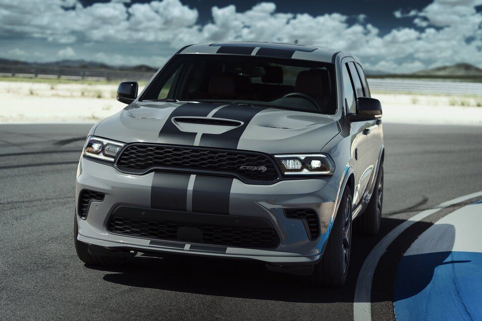 A silver dodge durango is parked on the side of a road.