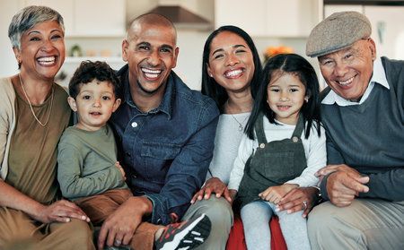 A family is posing for a picture together while sitting on a couch.