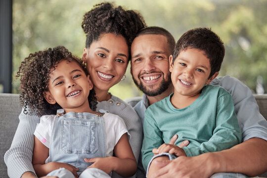 A family is posing for a picture while sitting on a couch.