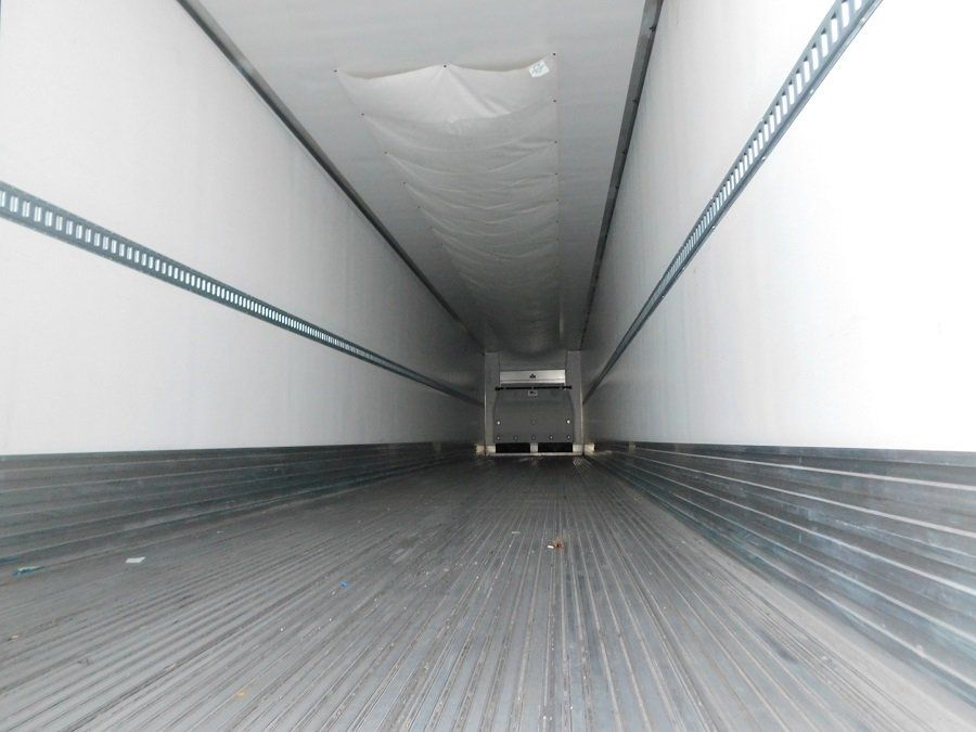 The inside of a trailer with a gray floor and white walls