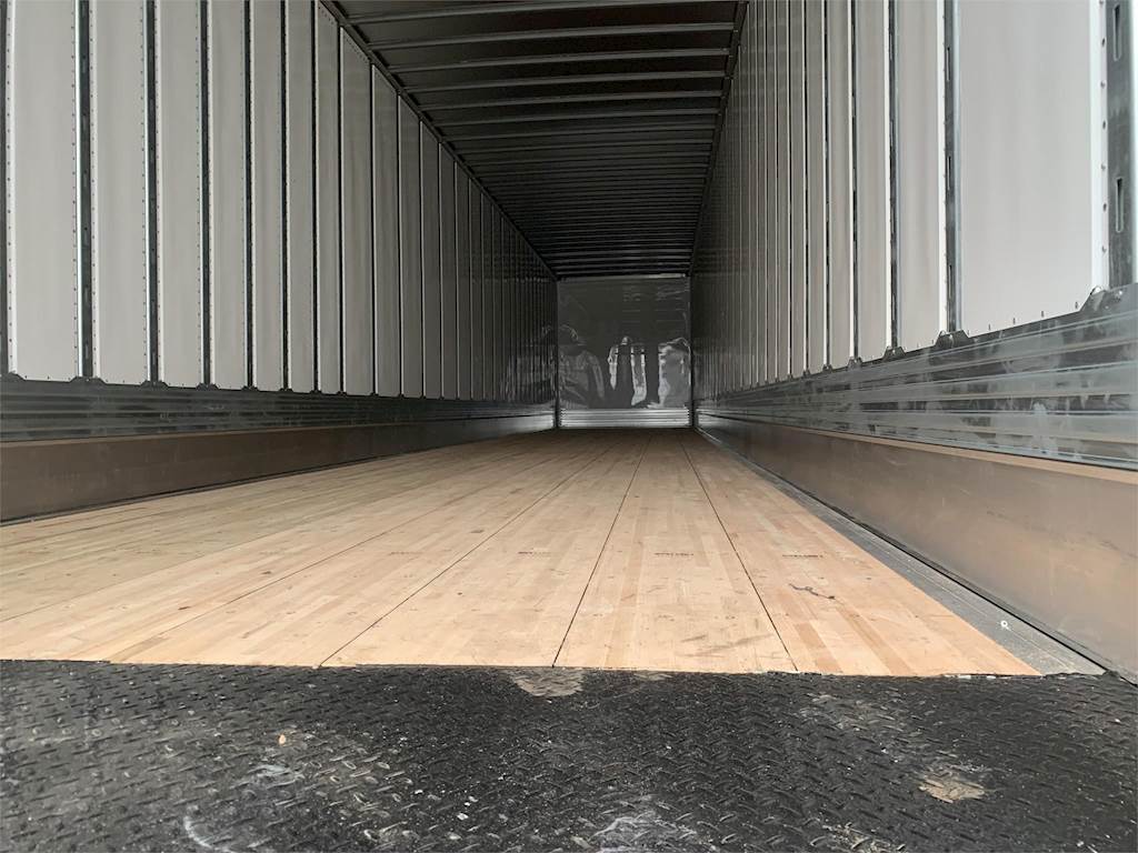 The inside of a trailer with a wooden floor.