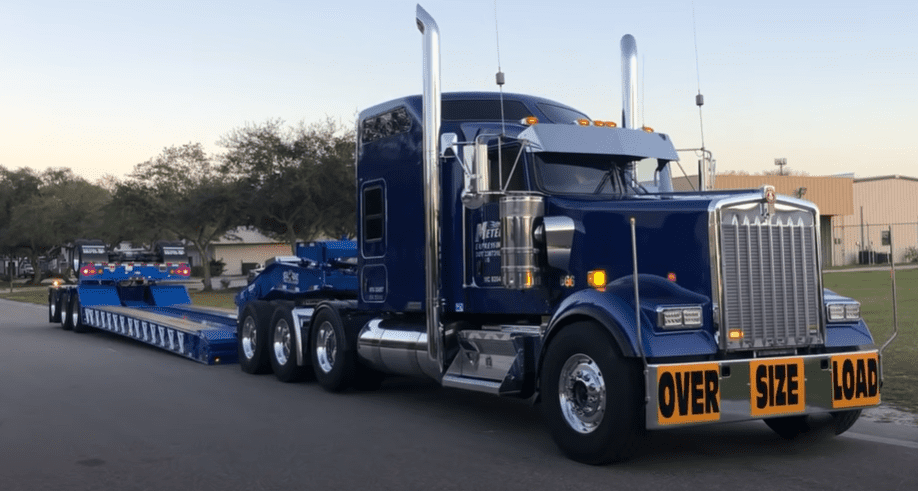 A blue semi truck is parked on the side of the road.