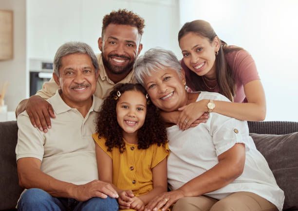 A family is posing for a picture while sitting on a couch.