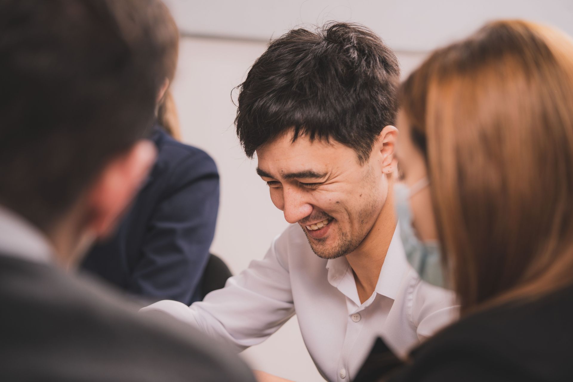People in a meeting smiling and talking around a table