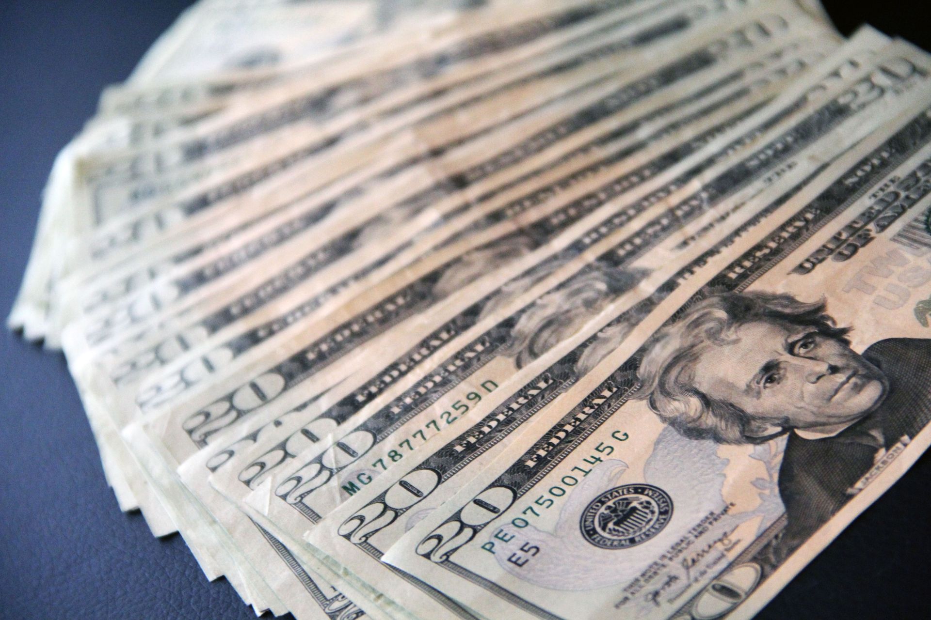 Fan of U.S. $20 bills spread on a surface, showing Andrew Jackson portrait