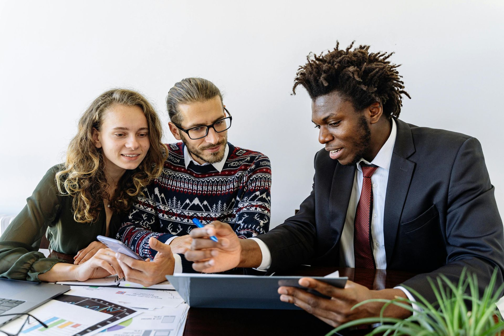 A professional discussing documents with a couple at a table in a bright office.