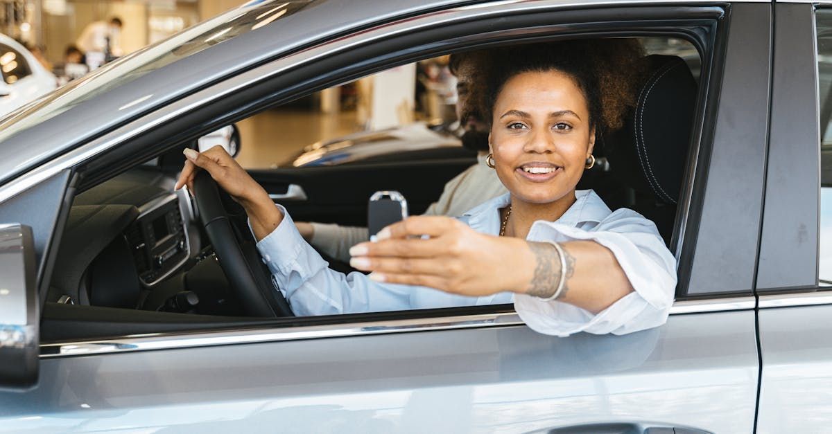 A woman is sitting in a car holding a car key.