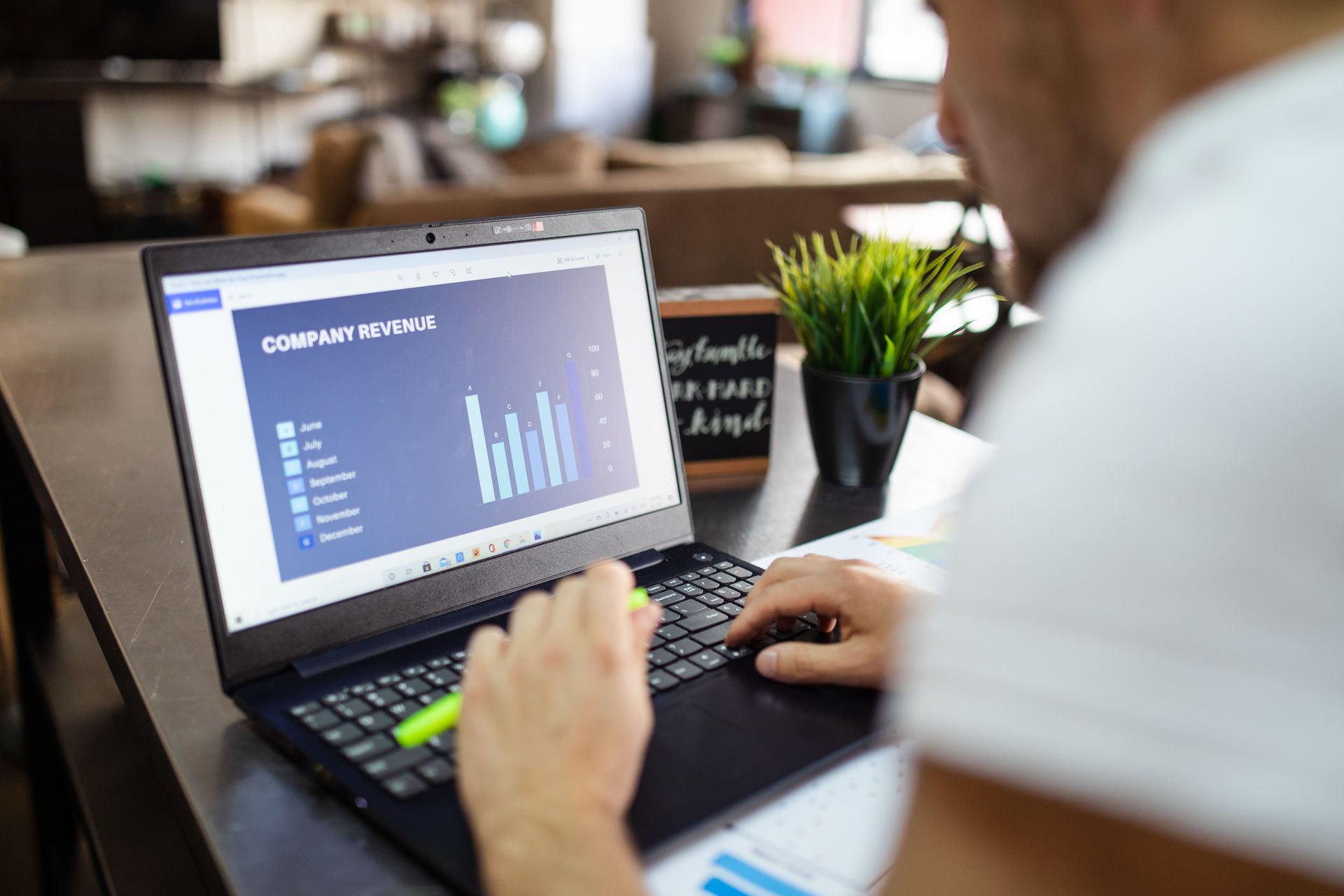 Person using a laptop with a data dashboard in a cafe