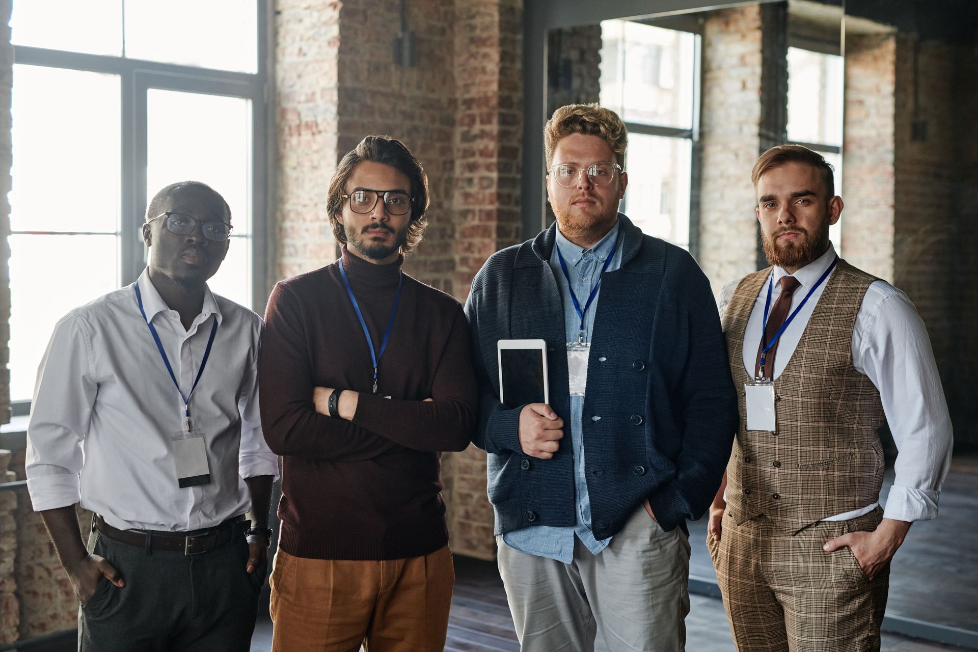 Four people standing in a bright office, wearing lanyards and looking at the camera.